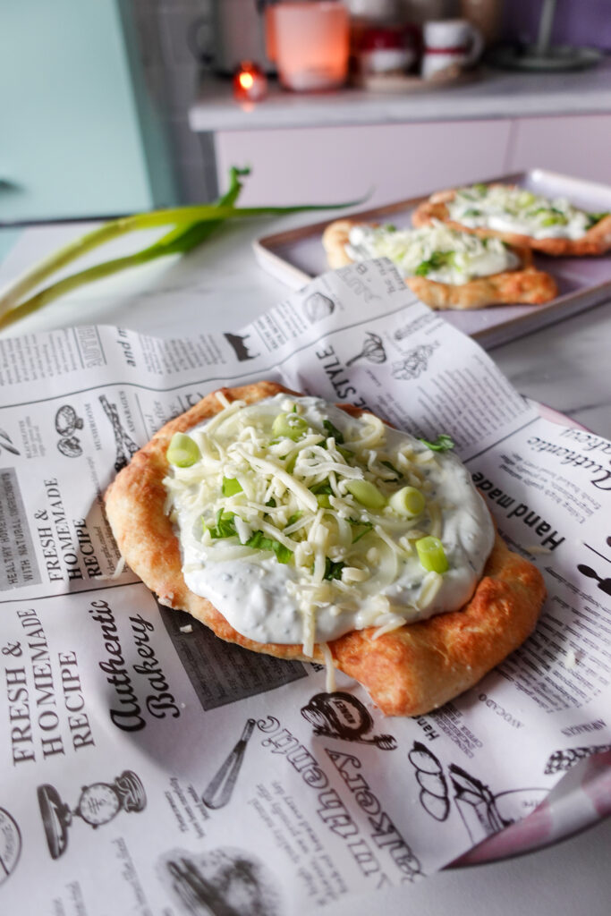 Protein Lángos aus dem Airfryer belegt mit Knoblauch-Dip, Frühlingszwiebeln und geriebenem Käse